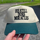 He Still Does Miracles Trucker Hat